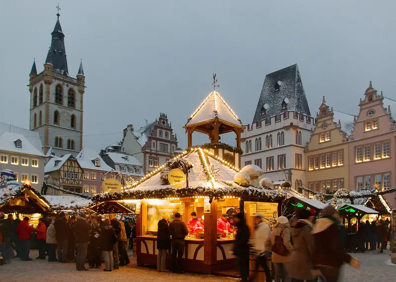 Kerstmarkt op de Hauptmarkt van Trier met de kerktoren erachter